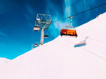 Low angle view of overhead cable car against blue sky