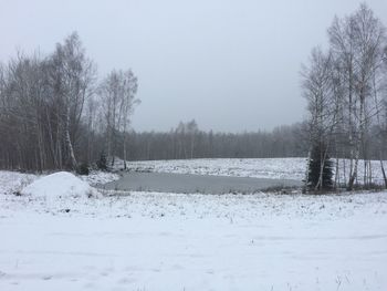 Snow covered field against clear sky