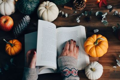 Low angle view of hand holding book on table