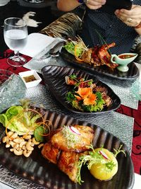 Midsection of person photographing of food served on table