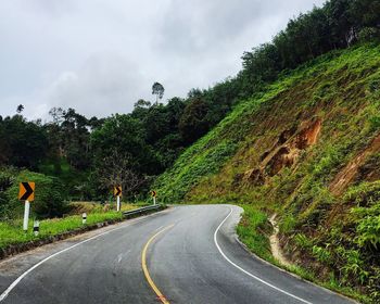 Curve road sign near mountain