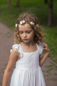 Girl wearing wreath while standing at public park