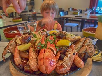 Seafood served on table with boy in background at restaurant