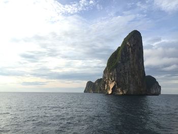 Rock formation in sea against sky