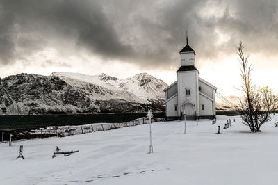 House on snow covered mountain against sky