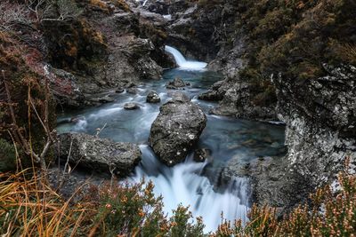 Scenic view of waterfall stream amidst plants