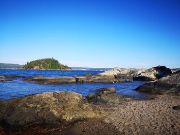 Scenic view of beach against clear blue sky