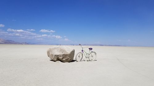 People sitting on desert against sky