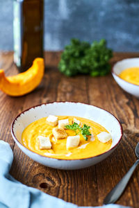 Pumpkin puree soup with croutons and a sprig of parsley. vertical photo. place for text.