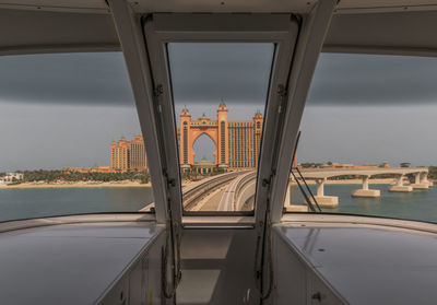 Bridge in city against cloudy sky