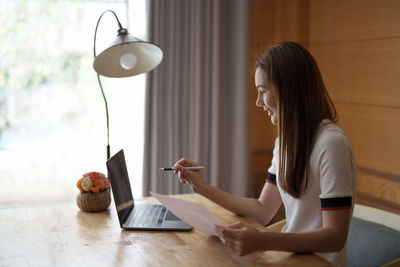 Smiling businesswoman talking on video conference at office