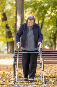 Senior woman walking with walker at park