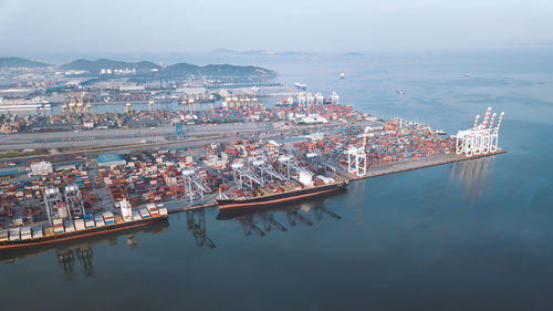 High angle view of city by sea against sky