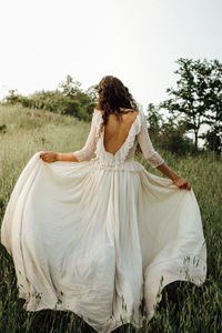 Rear view of woman with umbrella on field