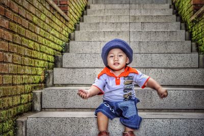 Portrait of smiling boy sitting on staircase