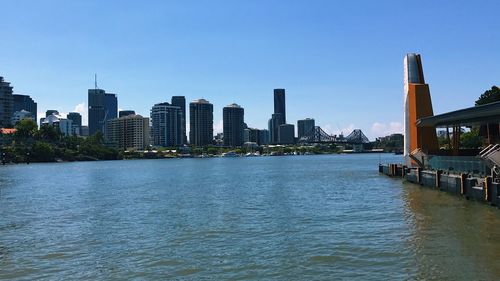 River and buildings against clear sky