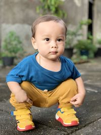 Portrait of cute boy with toy sitting outdoors
