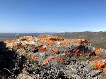 View of rocks on landscape against blue sky