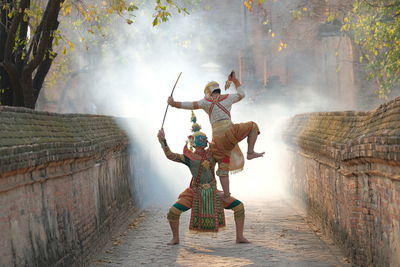 Men wearing traditional clothing performing on street