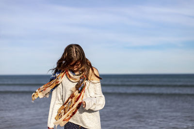 Rear view of man standing in sea against sky