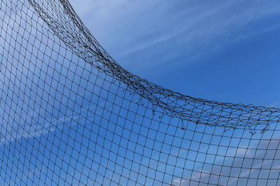 Low angle view of fence against blue sky