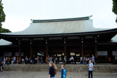 People at temple against sky in city