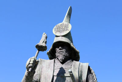 Low angle view of statue against blue sky