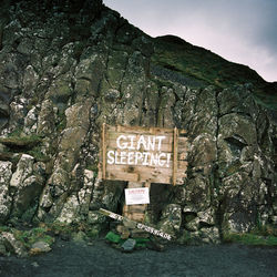 Close-up of signboard against the sky