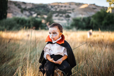 Portrait of boy standing on field