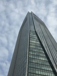 Low angle view of modern building against cloudy sky