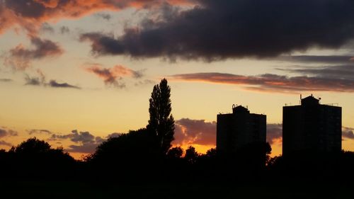 Silhouette city against sky during sunset