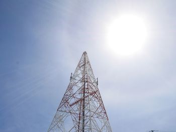 Low angle view of communications tower against sky on sunny day