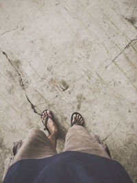 Low section of man standing on tiled floor