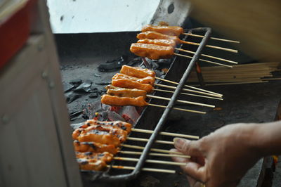 Person preparing food on barbecue grill