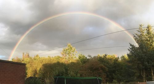 Low angle view of rainbow against cloudy sky