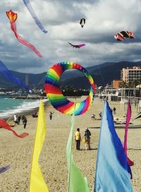 People enjoying at beach against sky