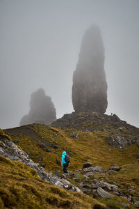 Hiker standing on mountain during foggy weather