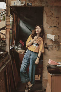 Portrait of young woman sitting in abandoned house