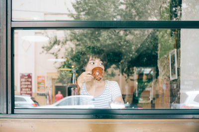 Woman drinking coffee while sitting at cafe