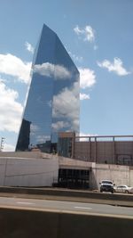 Low angle view of modern building against cloudy sky