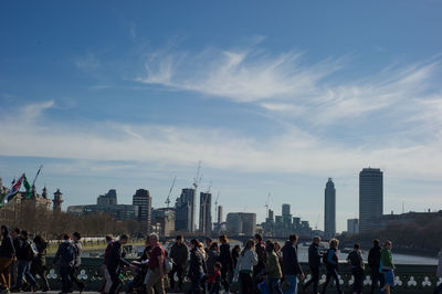 Crowd at city against sky