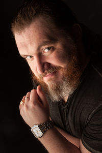 Portrait of young man against black background