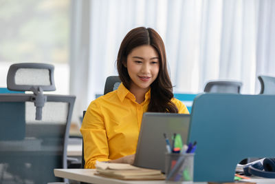 Beautiful businesswoman looking at laptop in office