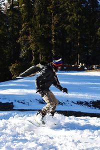 Person paragliding on snow covered land