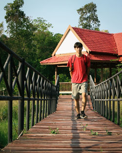 Full length of teenage girl standing on footbridge