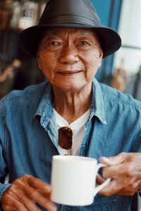 Portrait of senior man having coffee while sitting in cafe