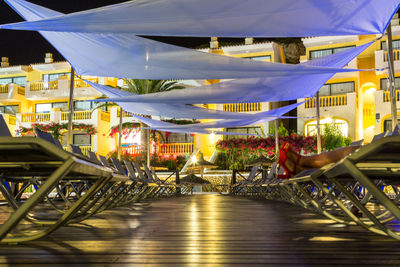 Illuminated restaurant by buildings in city at night