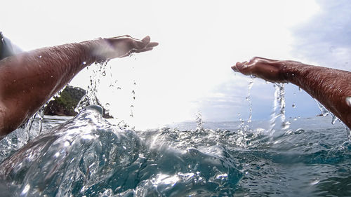 Man splashing water against sky