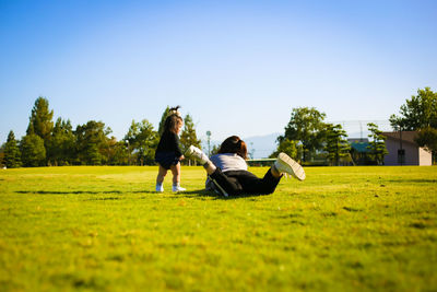 Mother with daughter on grassy land