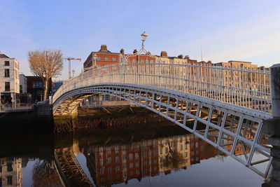 Bridge over river in city against clear sky